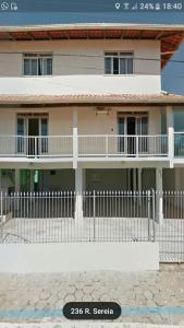 a white fence in front of a house at Residencial Costa do Encanto in Penha