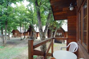porche de una cabaña con mesa y silla en Hakuba Brownie Cottages, en Hakuba