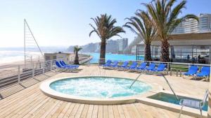 阿爾加羅沃的住宿－San Alfonso del Mar Puerto del Sur，一个带蓝色躺椅的游泳池和海滩