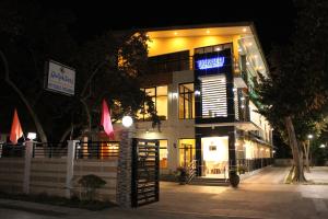 a building with a sign on it at night at Ralphseej Pension House in Moalboal