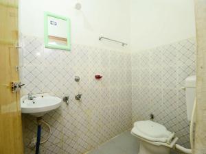 a bathroom with a toilet and a sink at Surya Inn in Konārka