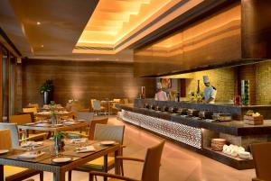a restaurant with tables and chairs and a bar at The Lalit Mangar in Faridabad