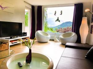 un soggiorno con due sedie bianche e una grande finestra di Casa Alma a Neuenweg