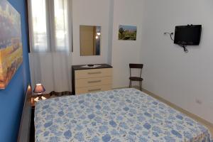 1 dormitorio con 1 cama, vestidor y silla en Bilocali Civico16, en Porto Cesareo