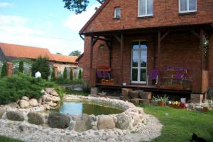 a house with a pond in the yard at Sloneczna Weranda in Wydminy