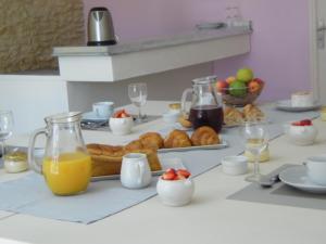 a breakfast table with a tray of pastries and orange juice at La Fralinette in Fralignes