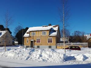 una casa está cubierta de nieve en un patio en FirstHome GuestHouse, en Jakobstad