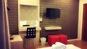 La salle de bains est pourvue d'une télévision sur un mur carrelé. dans l'établissement P-Residence, à Hat Yai