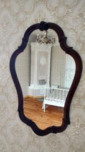 a mirror hanging on a wall with a crib in a room at Centrum Studio in Liepāja