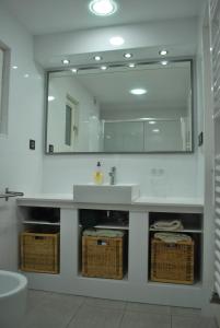 カレーリャにあるApartamento Con Fabulosa Terrazaのバスルーム(シンク、鏡、バスケット付)