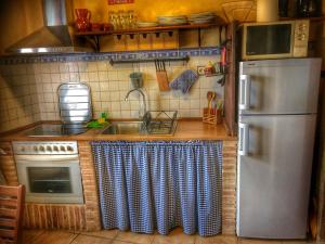 a kitchen with a sink and a refrigerator at El Jardín Secreto in Orés