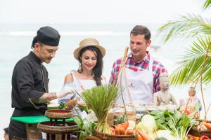 a group of people standing around a table with vegetables at Muang Samui Spa Resort in Chaweng
