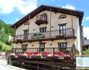 a building with tables and chairs in front of it at Albergo Passet in Pragelato