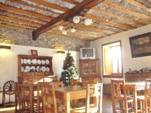 ein Esszimmer mit einem Weihnachtsbaum, einem Tisch und Stühlen in der Unterkunft Albergo Passet in Pragelato