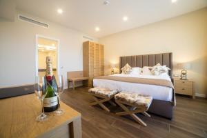 a bedroom with a bed and a bottle of wine at Thassos Grand Resort in Alyki