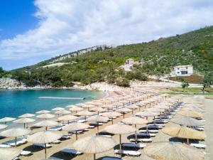 a bunch of umbrellas on a beach with the ocean at Thassos Grand Resort in Alyki