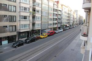 une rue avec des voitures garées sur le côté d'un bâtiment dans l'établissement Royal Plage Oostende, à Ostende