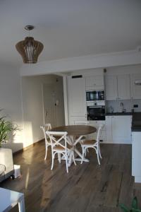 una cucina e una sala da pranzo con tavolo e sedie di Royal Plage Oostende a Ostenda
