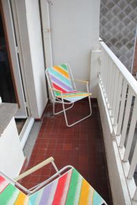una sedia colorata seduta su un portico accanto a una scala di Royal Plage Oostende a Ostenda