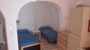 オストゥーニにあるAppartamento Ostuni Anticaの青いベッド2台が備わる客室です。