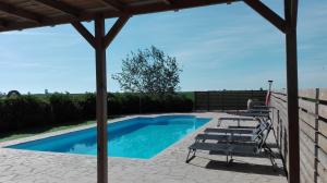 a swimming pool with lounge chairs and a pavilion at Mas del Tancat in Amposta