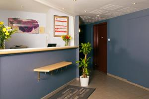 a waiting room with a bench and a blue wall at Séjours & Affaires Paris-Nanterre in Nanterre