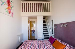una pequeña habitación con una cama y una escalera en Bel Ombra Hôtel, en Bandol