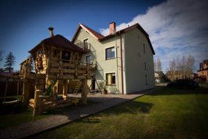a house with a tree house in front of it at Villa Remedios in Łeba