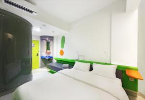 a bedroom with a white bed and a green wall at POP! Hotel Tebet Jakarta in Jakarta