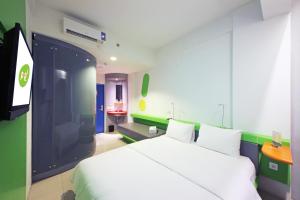 1 dormitorio con 1 cama blanca y TV en POP! Hotel Tebet Jakarta en Yakarta