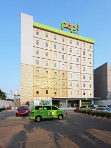 a green car parked in front of a hotel at POP! Hotel Tebet Jakarta in Jakarta