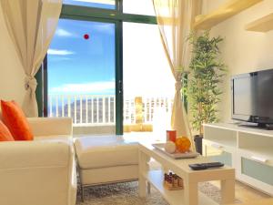 un soggiorno con divano e una grande finestra di AMADORES BEACH & OCEAN VIEWS ad Amadores