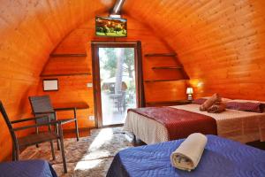 a bedroom with two beds in a wooden cabin at Campeggio Sanfilippo in Cefalù