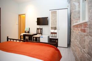 a bedroom with a bed and a desk and a television at Apartments Galić in Split