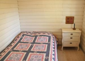 een slaapkamer met een bed en een nachtkastje met een quilt bij Karrebæksminde in Enø By