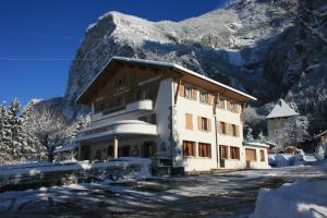 un bâtiment dans la neige avec une montagne en arrière-plan dans l'établissement Le Relais Du Mont Blanc, à Magland