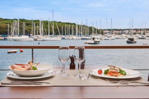 a table with two plates of food and wine glasses at Ribarska Koliba Resort in Pula