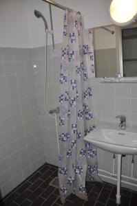 a bathroom with a shower curtain and a sink at Hotel Lakolk in Rømø Kirkeby
