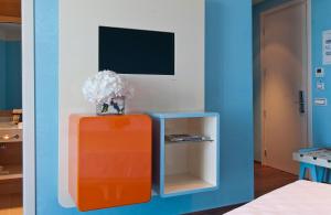 a room with an orange cabinet and a vase of flowers at JR Hotels Bari Grande Albergo delle Nazioni in Bari