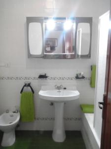 y baño con lavabo, aseo y espejo. en Vivienda uso turistico con WiFi, en Villarcayo