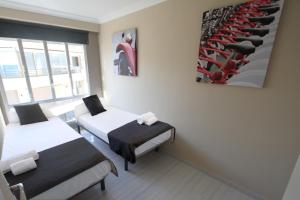 サロウにあるFor a Stay Bello Horizonteのベッド2台とクローゼットが備わる客室です。