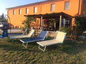 un grupo de sillas sentadas en el césped frente a un edificio en B&B Aesis La Dolce Collina en Iesi