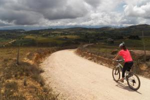 Una donna che va in bicicletta lungo una strada sterrata. di Hostal Juan Palitos a Los Santos