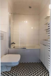 y baño con bañera, aseo y lavamanos. en Apartament przy Rotundzie, en Varsovia