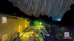 a view of a building at night with star trails at Yangshuo Yunshe Mountain Guesthouse in Yangshuo