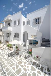 a white building with tables and chairs on a patio at Naxos Dream Aphrodite Studios in Naxos Chora