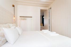 リスボンにあるFLH Bairro Alto Central Apartmentの白いベッド(白い枕付)が備わるベッドルームです。