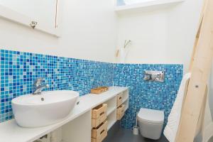 リスボンにあるFLH Bairro Alto Central Apartmentの青いタイルのバスルーム(洗面台、トイレ付)