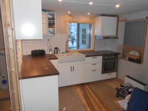 a kitchen with white cabinets and a sink at Lakeside House in Lapland in Skaulo