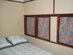 una camera da letto con un letto e due finestre di El Viejo Vagon 1908 a San Rafael Altre 35 foto